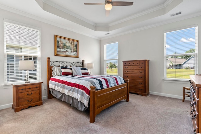 bedroom with a tray ceiling, ceiling fan, crown molding, and light colored carpet