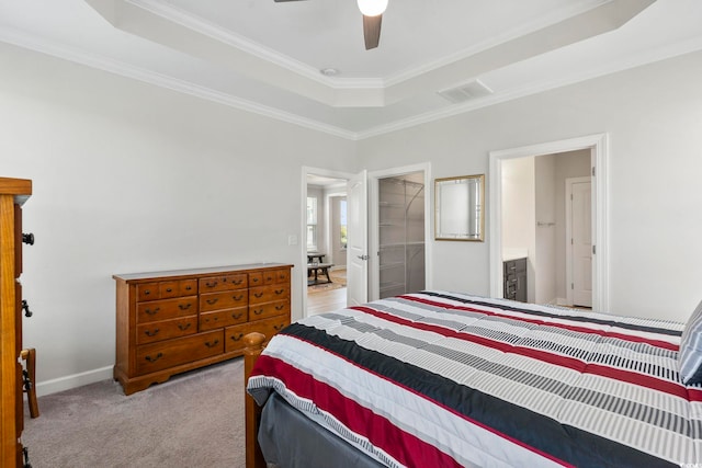 bedroom featuring ornamental molding, a raised ceiling, light colored carpet, ensuite bath, and a closet