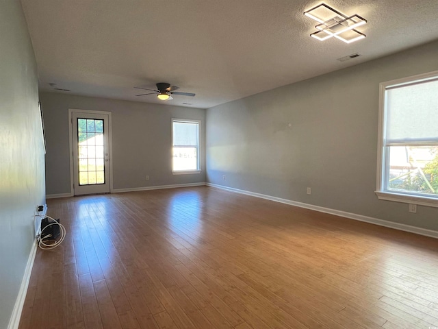 unfurnished room featuring light hardwood / wood-style floors, a textured ceiling, and ceiling fan