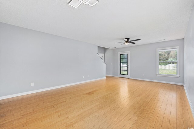 interior space featuring light wood-type flooring, ceiling fan, and baseboards