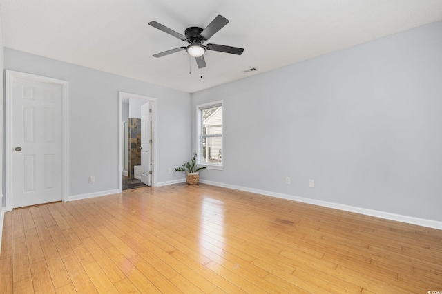 spare room featuring light wood finished floors, visible vents, baseboards, and a ceiling fan