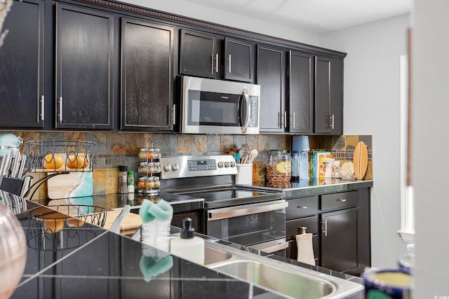 kitchen featuring stainless steel appliances, sink, dark brown cabinetry, a textured ceiling, and tasteful backsplash