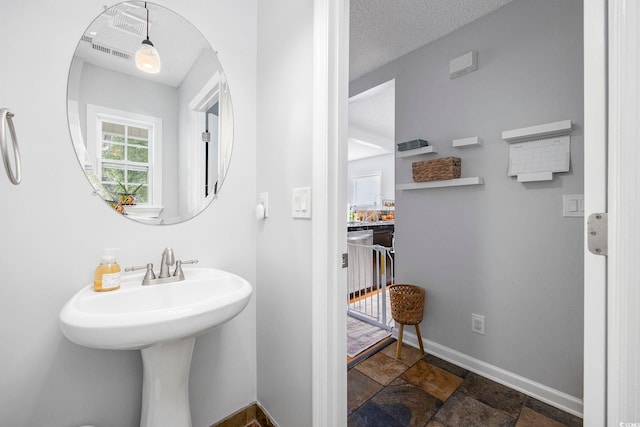 bathroom with a textured ceiling and sink