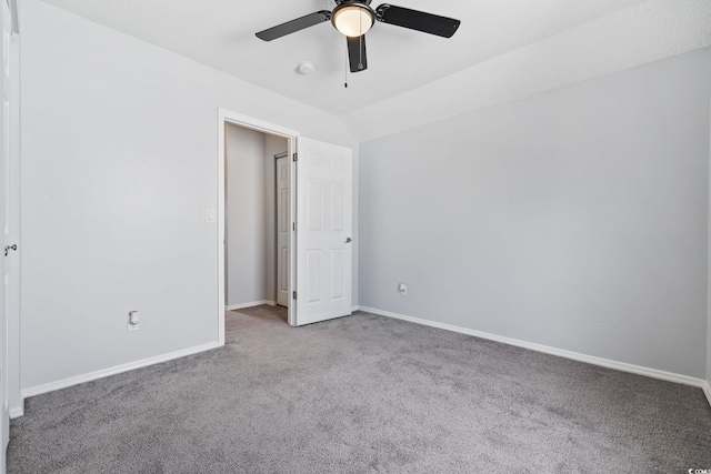 unfurnished bedroom with carpet floors, lofted ceiling, baseboards, and a ceiling fan