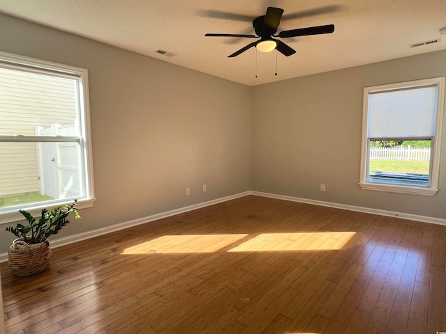 empty room with ceiling fan, a textured ceiling, and hardwood / wood-style floors