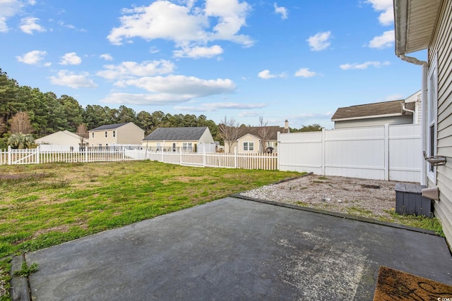 view of yard with a fenced backyard, a residential view, and a patio