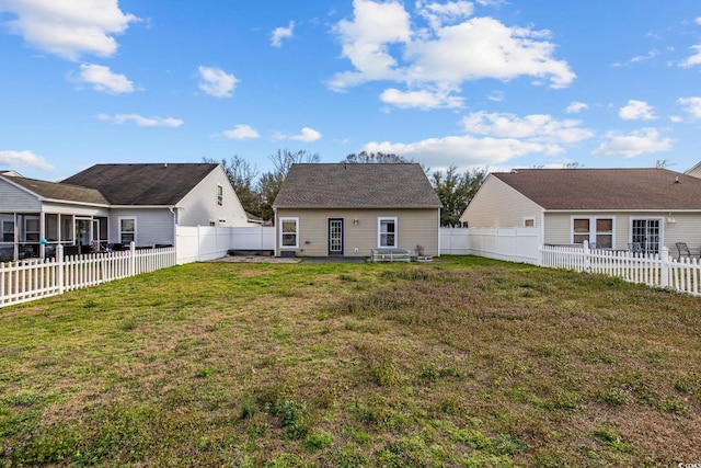 back of house featuring a fenced backyard and a lawn