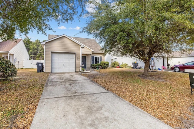 view of front facade with a garage, fence, and concrete driveway