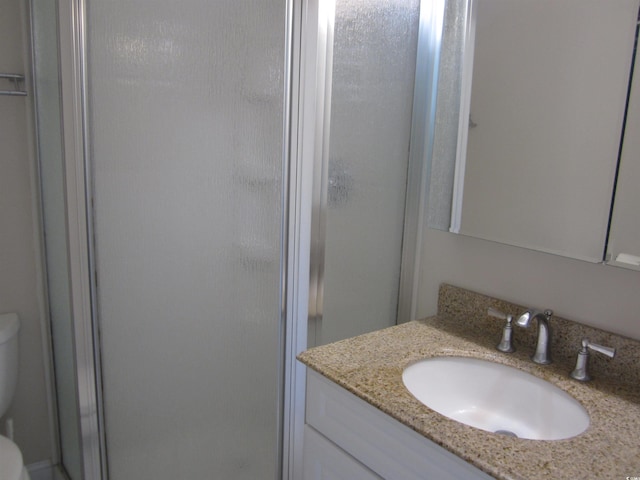 bathroom featuring walk in shower, vanity, and toilet