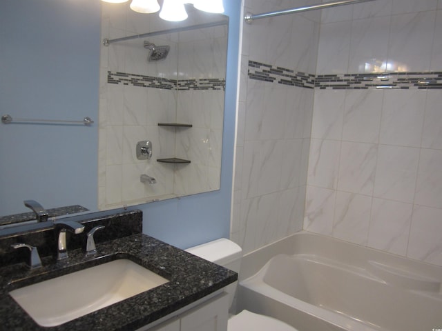 full bathroom with vanity, tiled shower / bath combo, and toilet