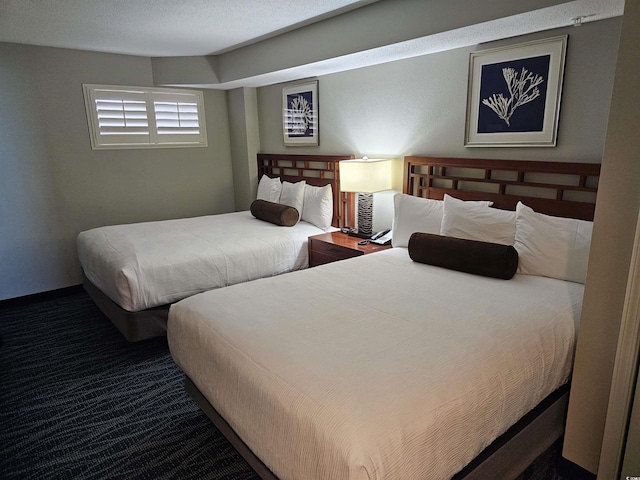 bedroom with dark colored carpet and a textured ceiling