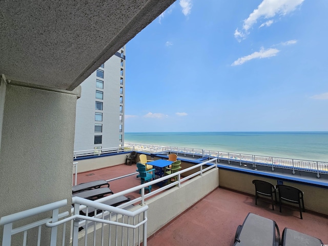 balcony featuring a water view and a beach view