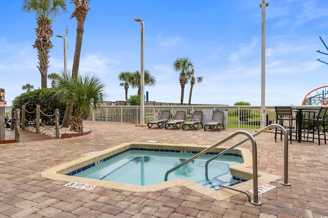 view of swimming pool featuring a hot tub