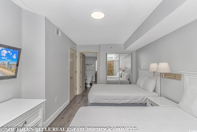 bedroom featuring a closet, a textured ceiling, and hardwood / wood-style floors