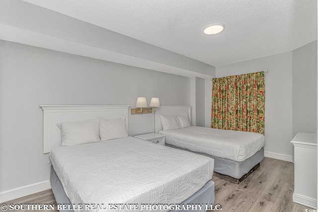 bedroom featuring a textured ceiling and light wood-type flooring