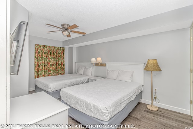 bedroom featuring ceiling fan, a textured ceiling, and light wood-type flooring