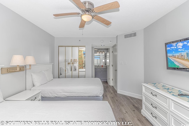 bedroom featuring ceiling fan, light wood-type flooring, and ensuite bathroom