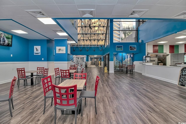 dining area featuring wood-type flooring and a paneled ceiling