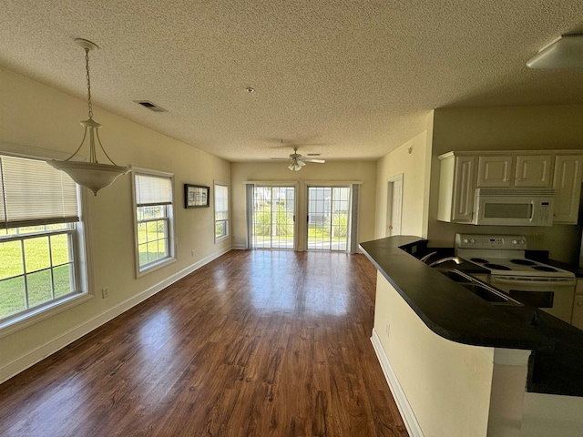 kitchen featuring decorative light fixtures, white appliances, plenty of natural light, dark wood-type flooring, and ceiling fan