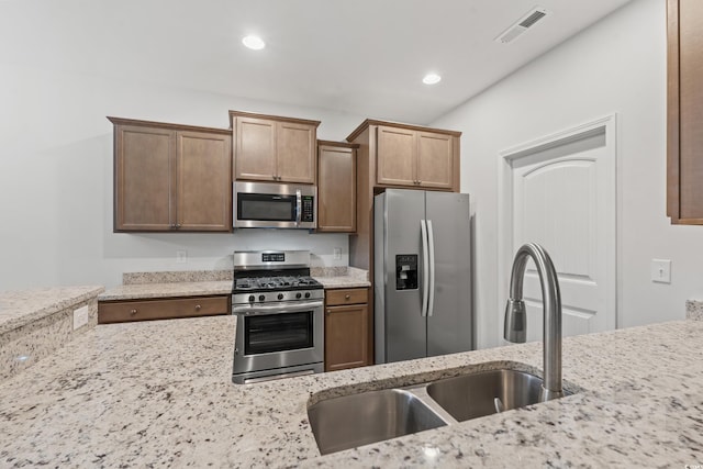 kitchen with visible vents, light stone counters, recessed lighting, stainless steel appliances, and a sink