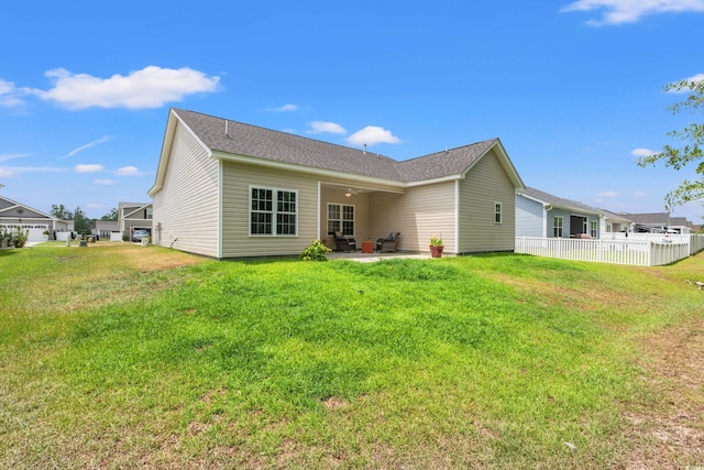 rear view of property with a patio and a lawn