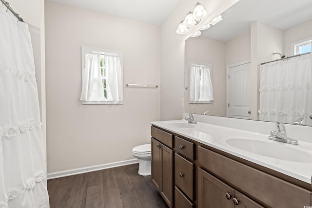 bathroom featuring a wealth of natural light, toilet, hardwood / wood-style floors, and vanity