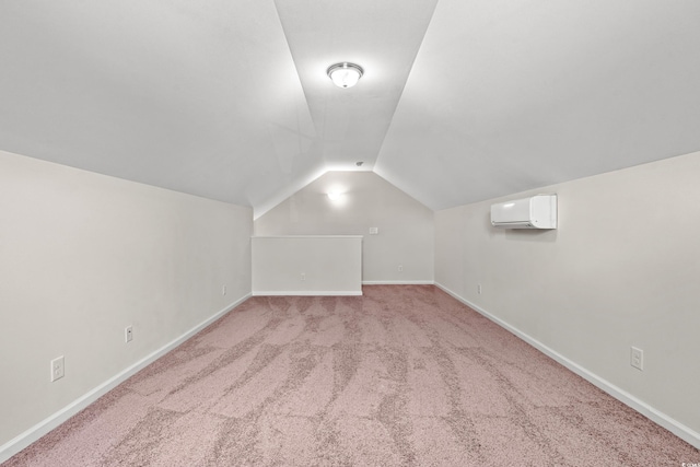 additional living space featuring vaulted ceiling, a wall mounted AC, and light colored carpet