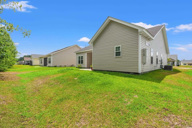 back of house featuring central AC and a yard