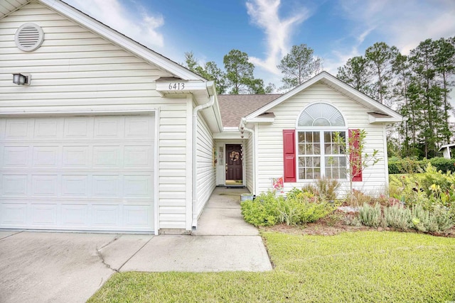 view of front of property featuring a garage and a front yard