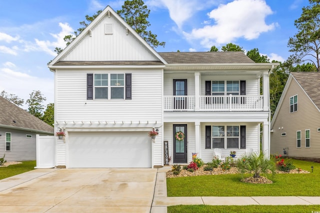 view of front of house featuring a balcony, a front yard, and a garage