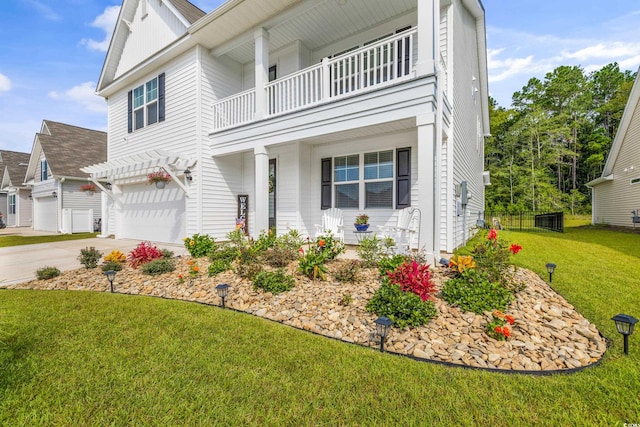 view of front of house with a garage, a balcony, and a front yard