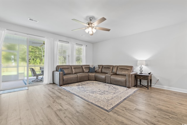 living room with light hardwood / wood-style floors and ceiling fan