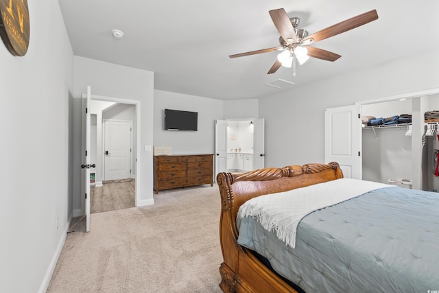 bedroom with a walk in closet, a closet, ceiling fan, and light colored carpet