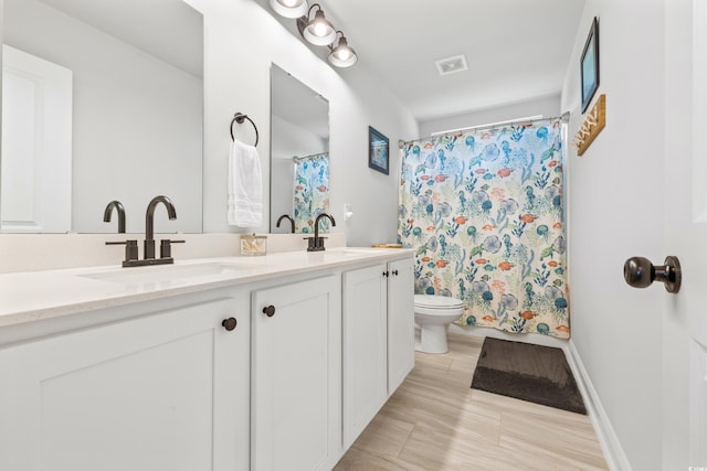 bathroom with tile patterned floors, dual vanity, and toilet