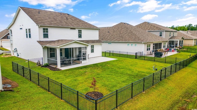 rear view of property featuring a patio area, a sunroom, and a yard