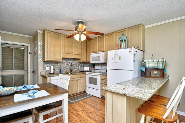 kitchen with light hardwood / wood-style floors, white appliances, crown molding, ceiling fan, and sink