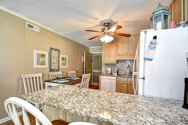 kitchen featuring sink, white appliances, backsplash, light stone countertops, and ceiling fan