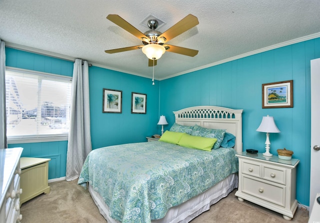 carpeted bedroom featuring ceiling fan, a textured ceiling, and crown molding