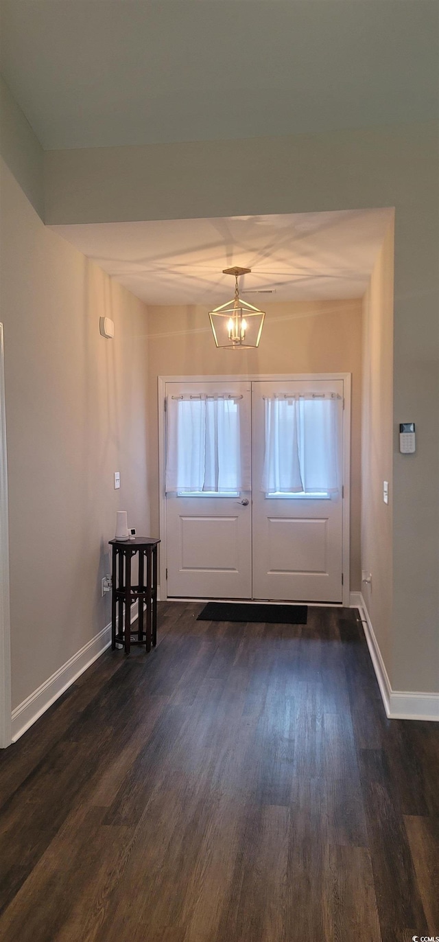 foyer entrance featuring dark hardwood / wood-style flooring and an inviting chandelier