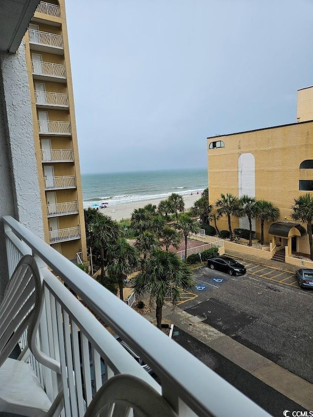 balcony featuring a beach view and a water view