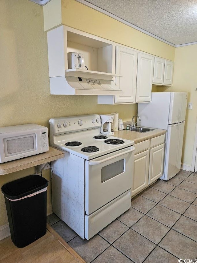 kitchen featuring sink, range hood, white cabinets, white appliances, and light tile patterned floors