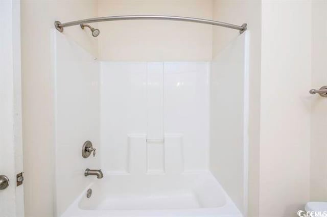 bathroom featuring toilet and shower / tub combination