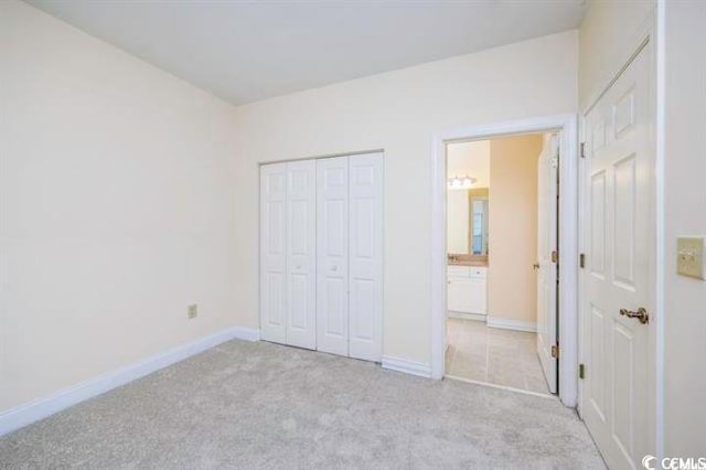 unfurnished bedroom featuring a closet and light carpet