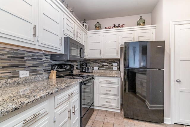 kitchen featuring light stone counters, light tile patterned flooring, white cabinetry, black appliances, and tasteful backsplash