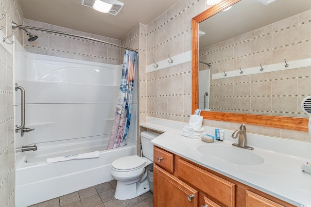 bathroom with toilet, shower / tub combo with curtain, tile patterned flooring, vanity, and tile walls