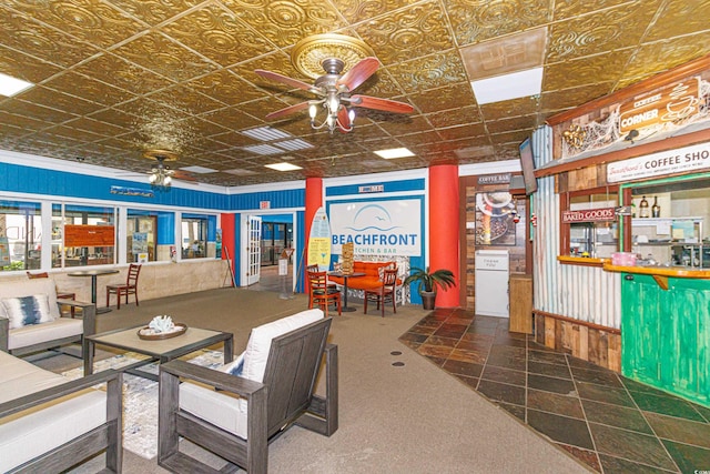 interior space with ceiling fan, dark carpet, and an ornate ceiling