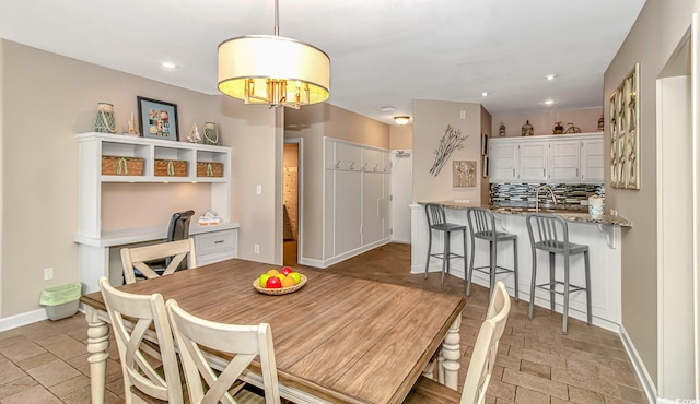 dining space featuring stone finish floor, recessed lighting, and baseboards