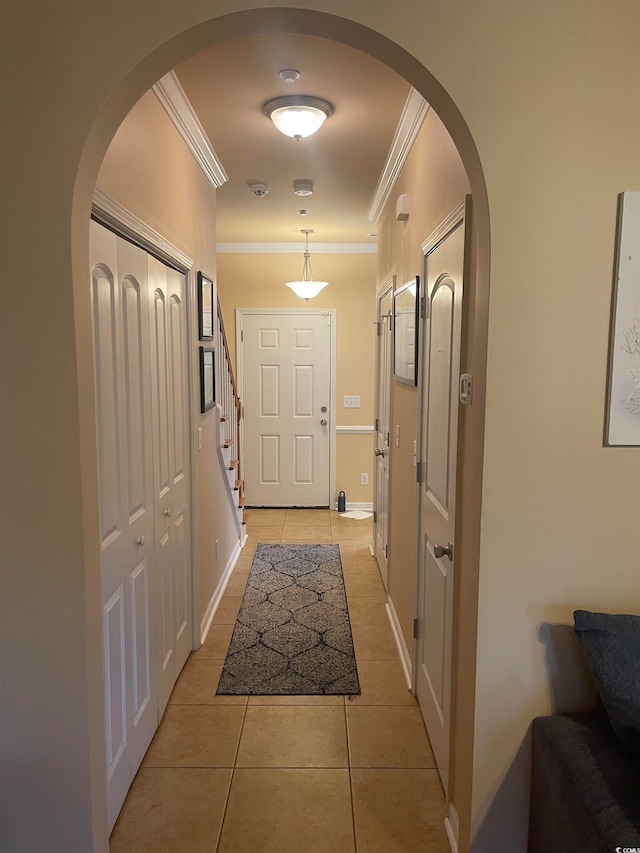 doorway to outside featuring light tile patterned flooring and ornamental molding