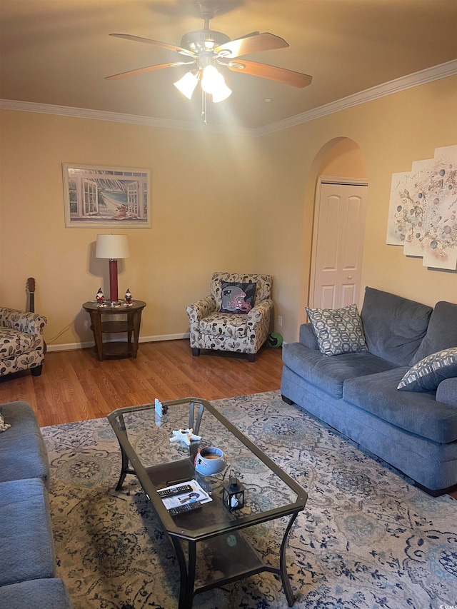 living room with ceiling fan, crown molding, and wood-type flooring