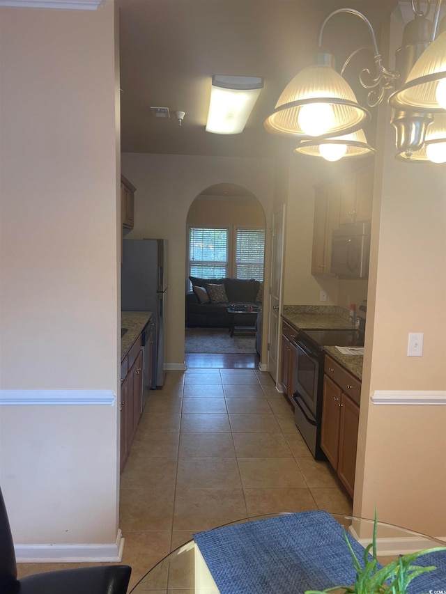 kitchen featuring refrigerator, electric stove, and light tile patterned flooring